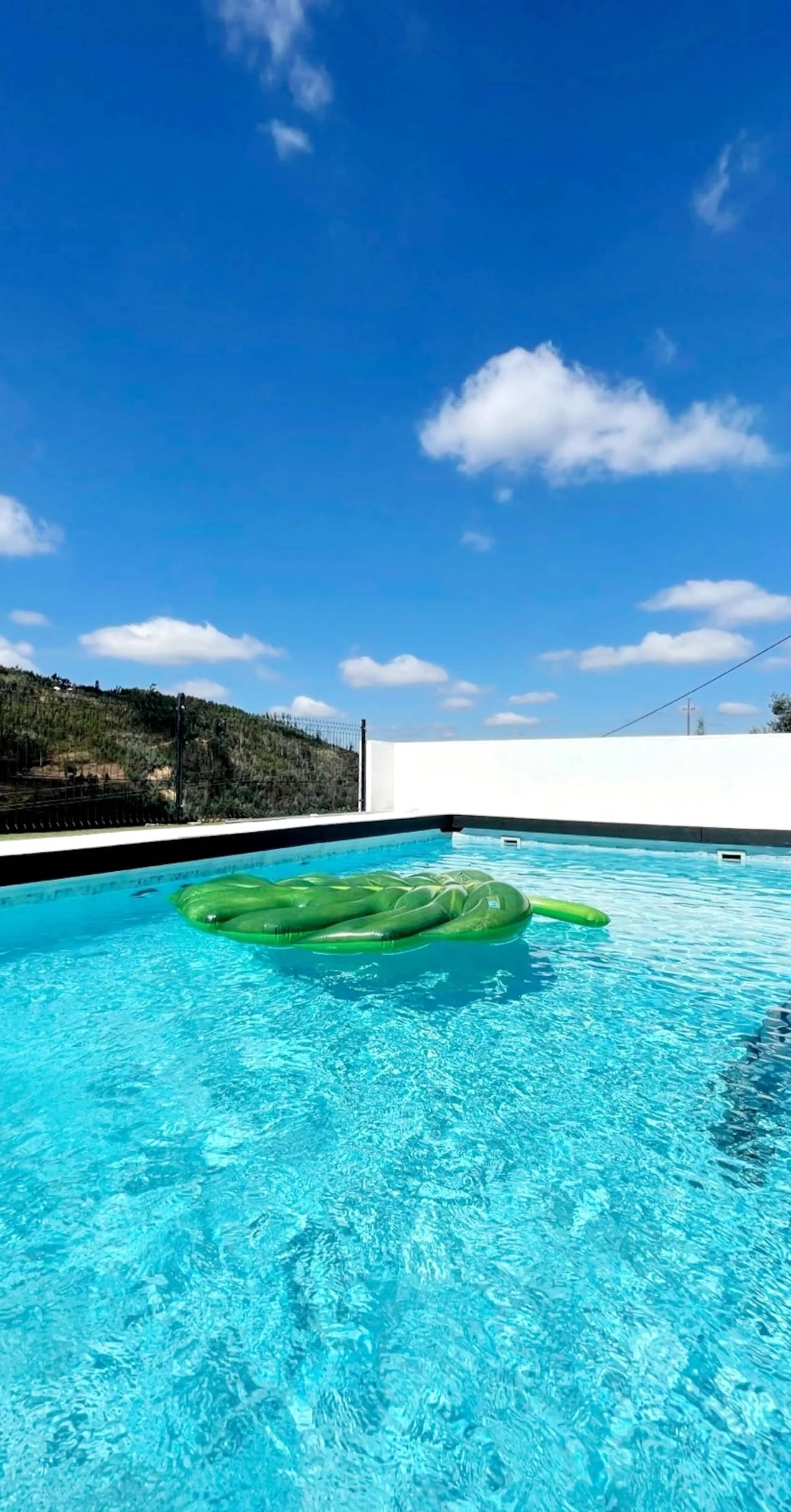Piscina com águas cristalinas e céu azul sobre a Serra do Açor